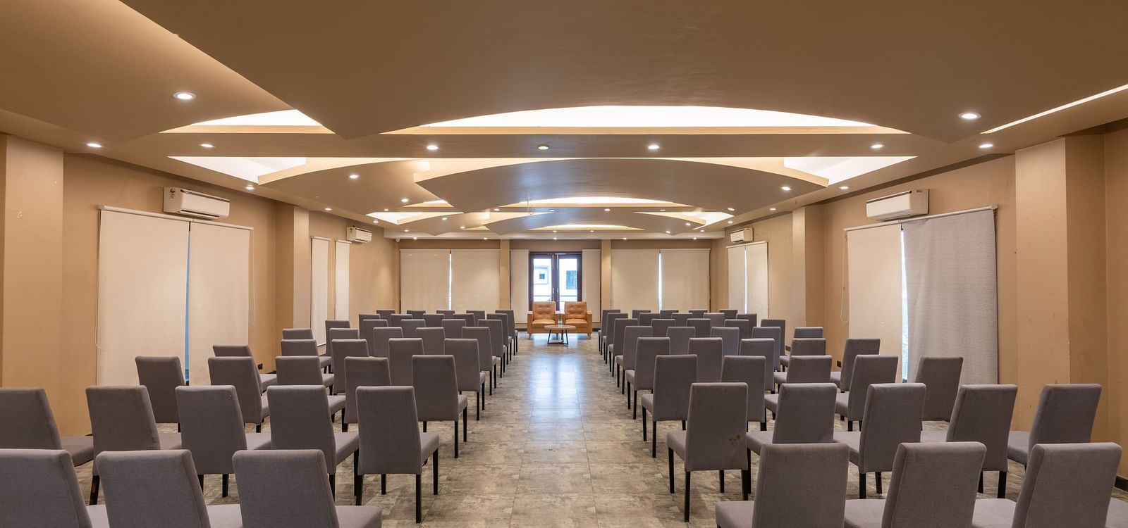 View from the back of the banquet hall at DLS Forest Vines Resort, with chairs neatly arranged on both sides.